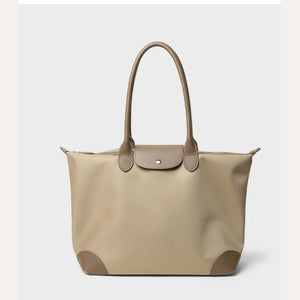 Light camel canvas travel tote with taupe flap, long handles and reinforced corners, front view