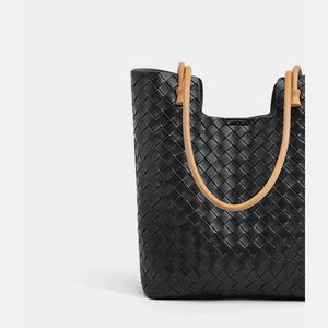 Close-up front view of black woven leather tote with tan shoulder straps